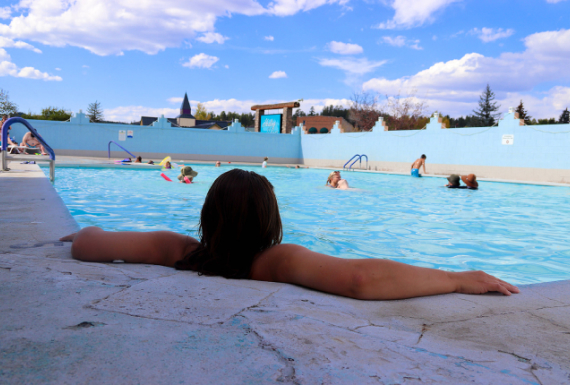 A woman relaxingly enjoying herself in the corner of a hot spring pool in Pagosa Springs Colorado.